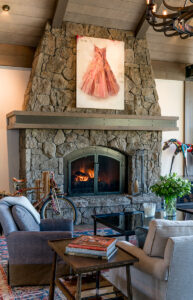 white clouds living room stone fire place wood beams light fixture